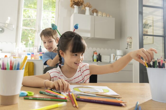 enfants qui colorient et s'amusent avec des fournitures scolaires