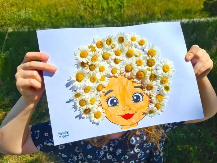 Enfant tenant un portrait de fillette dont la chevelure est faite de pâquerettes, dans une prairie : tableau floral en fleurs