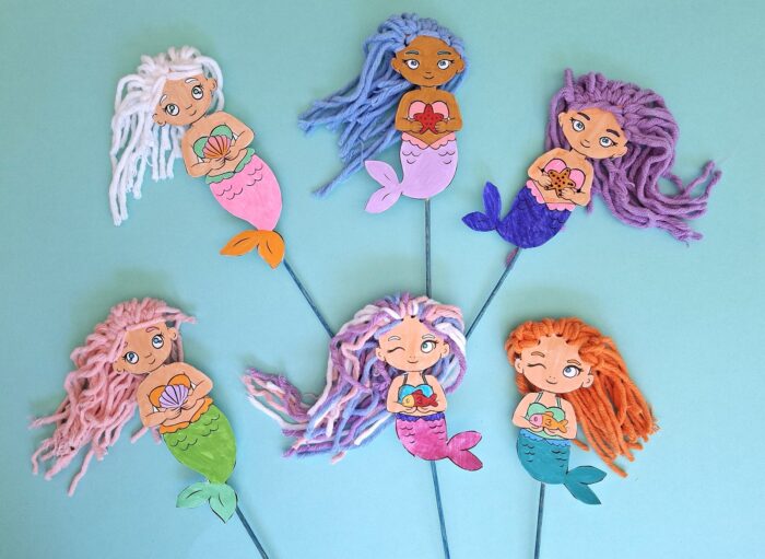 Six sirènes en papier aux chevelures de laine multicolores réalisées par des enfants