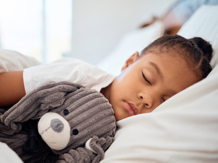 petite fille qui dort avec son doudou dans les bras